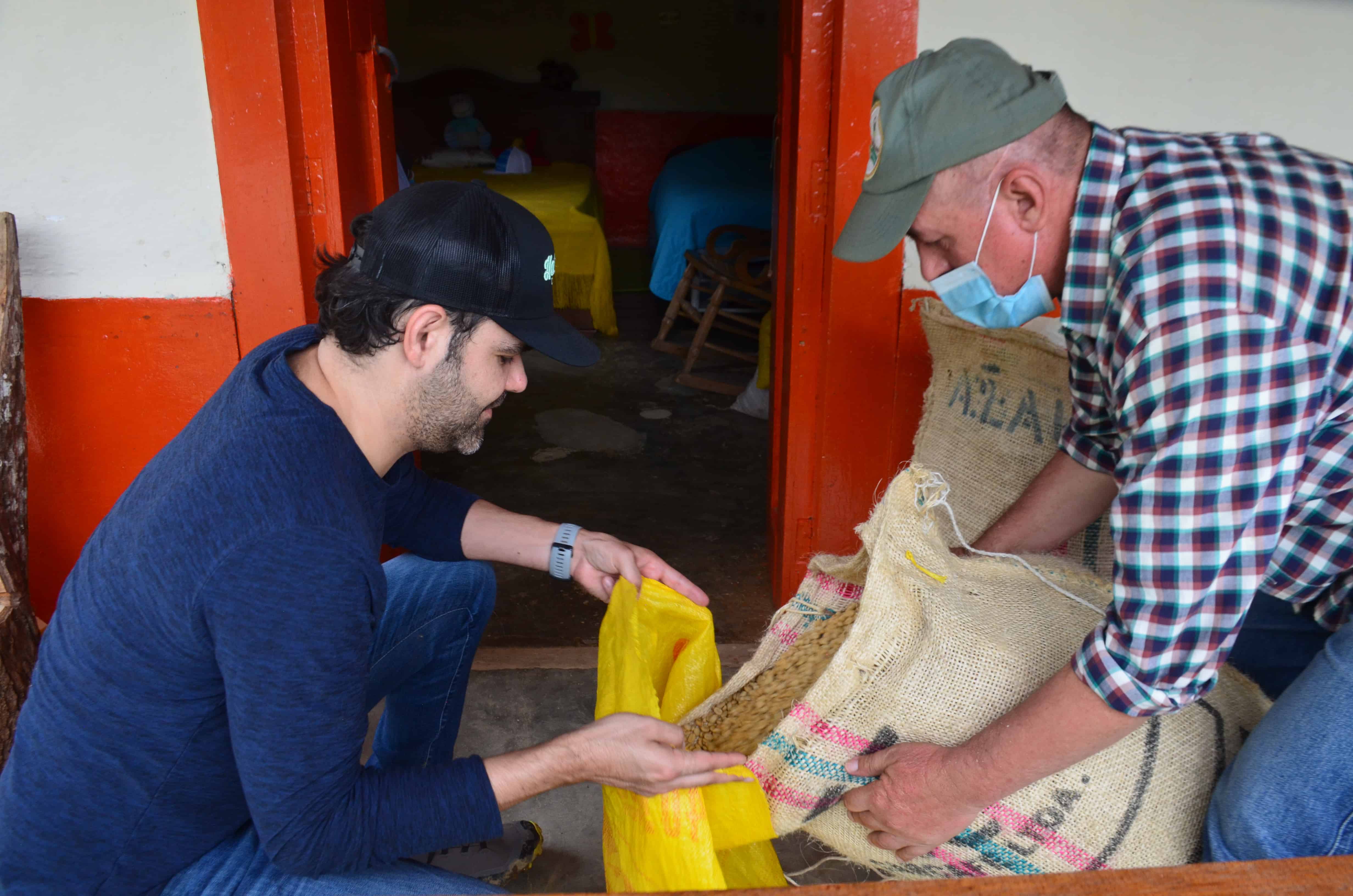 picture showing Jaime Rodriguez, Hatillo Coffee co-founder, and Raul Flores, farmer from La Teresita specialty coffee farm near Barbosa, Antioquia Colombia, transferring parchment coffee from bags